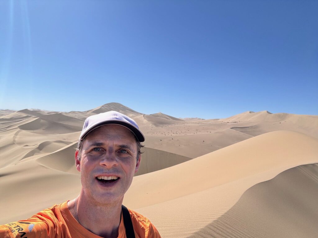 Rob Lilwall climbing sand dunes in Dunhuang, China